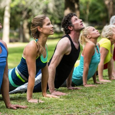 Fitness class practicing yoga in the park