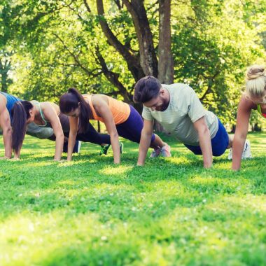 fitness, sport, friendship and healthy lifestyle concept - group of teenage friends or sportsmen exercising and doing push-ups at boot camp