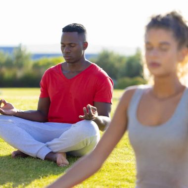 Group of diverse friends doing yoga and meditating in garden. Friendship, healthy and active lifestyle, summer, sunshine, unaltered.