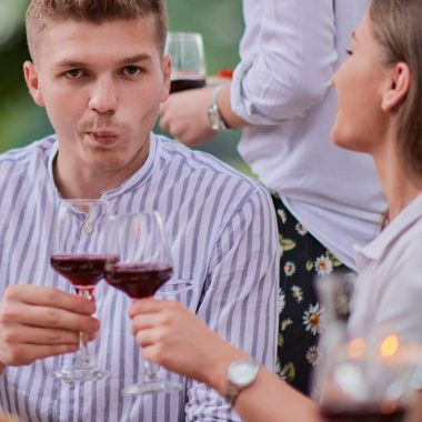 group of happy friends having picnic french dinner party outdoor during summer holiday vacation near the river at beautiful nature