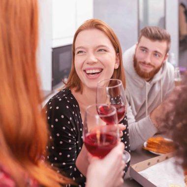 Happy friends meet for an aperitif at home