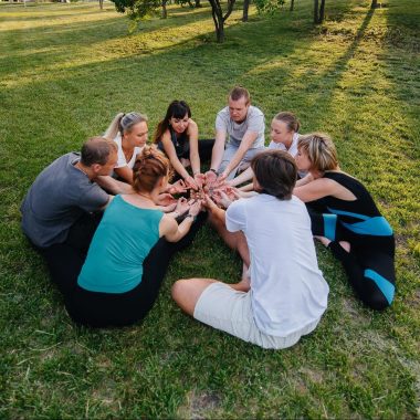 A group of people do yoga in a circle in the open air during sunset. Healthy lifestyle, meditation and Wellness