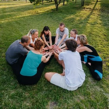 A group of people do yoga in a circle in the open air during sunset. Healthy lifestyle, meditation and Wellness
