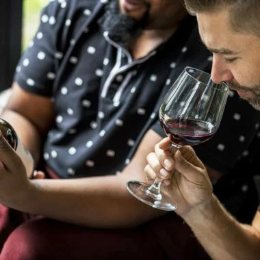 Man tasting red wine with friends