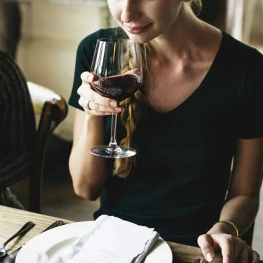 Woman Tasting Red Wine in a Classy Restaurant